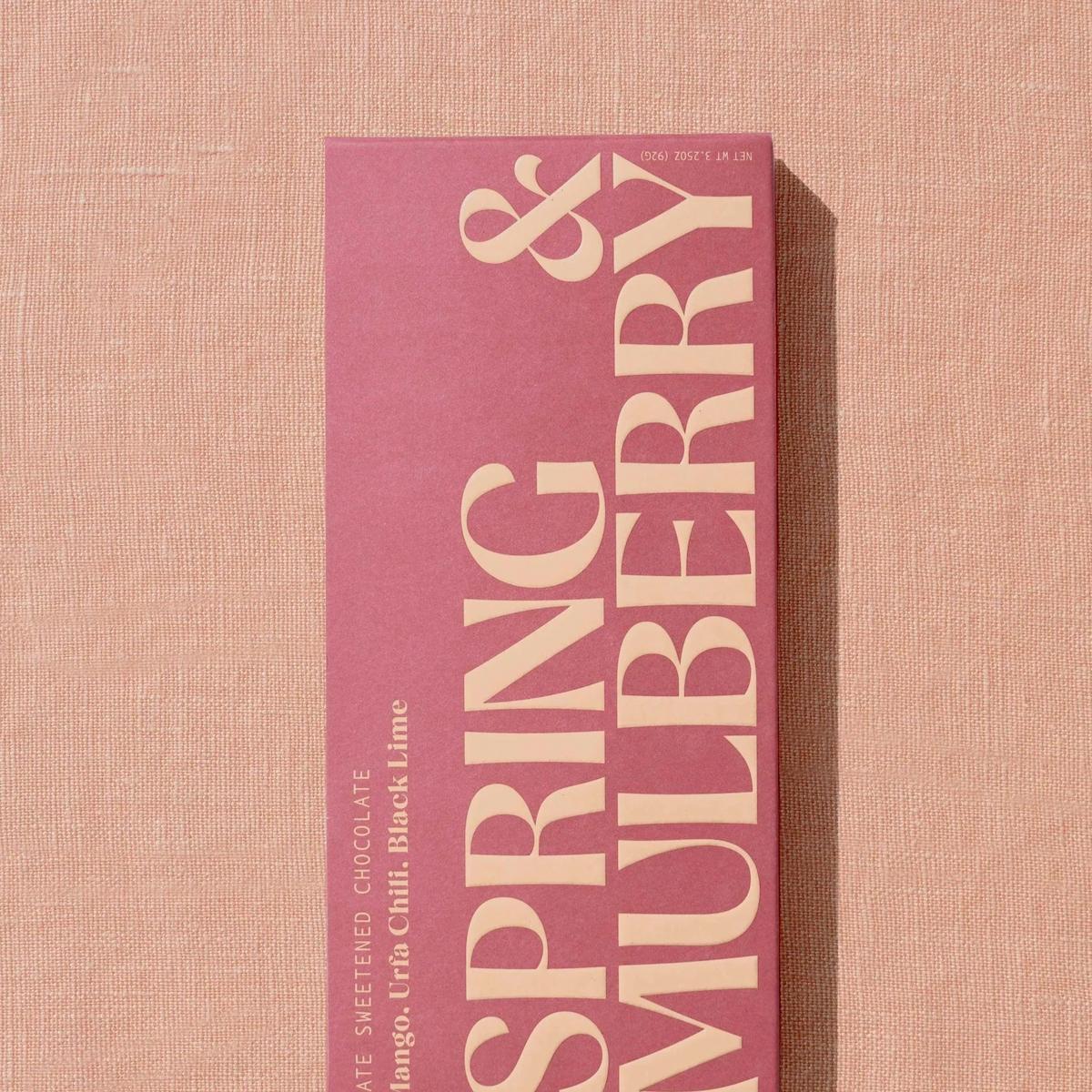 Pink book with 'Spring & Mulberry' text on a beige background