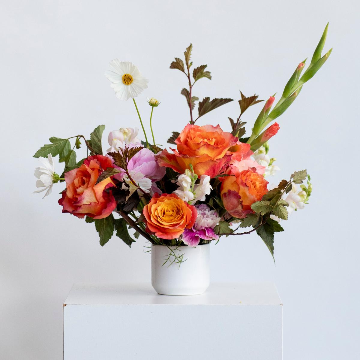 color centerpiece of flowers on a white background in a white vase 