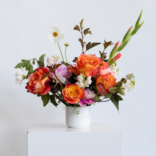 color centerpiece of flowers on a white background in a white vase 