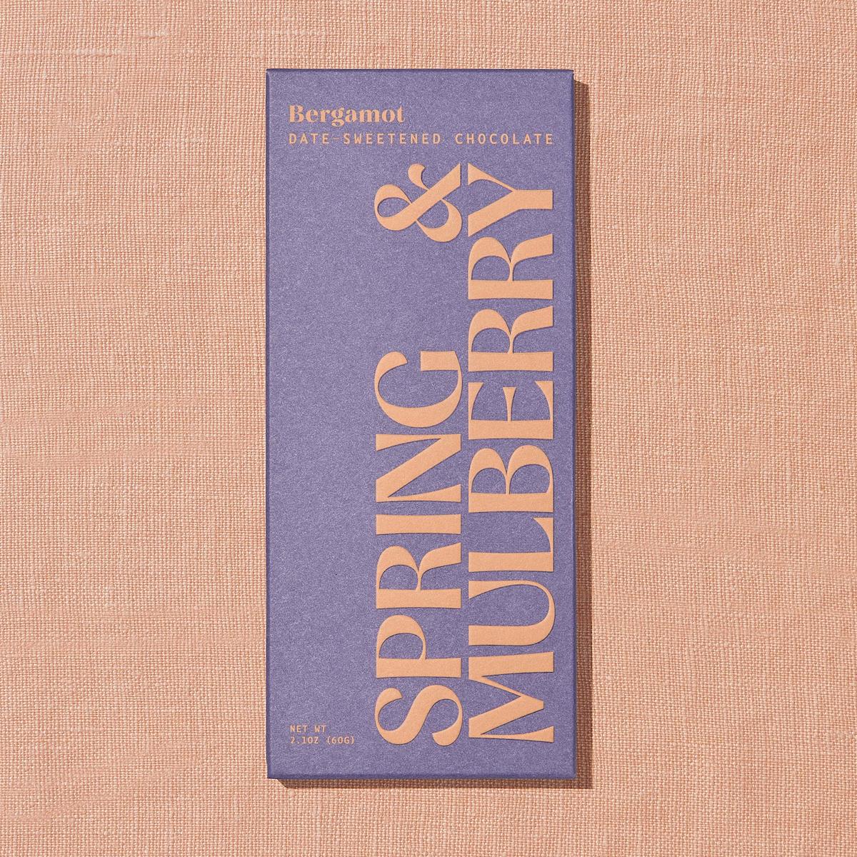Chocolate bar packaging with 'Spring & Mulberry' branding on a textured beige background