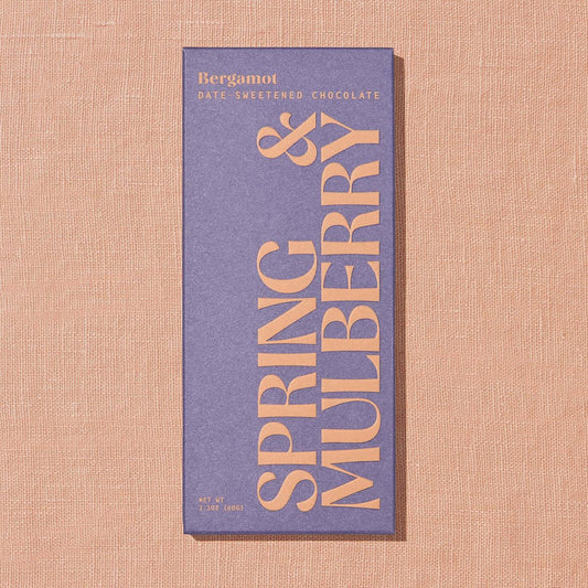 Chocolate bar packaging with 'Spring & Mulberry' branding on a textured beige background