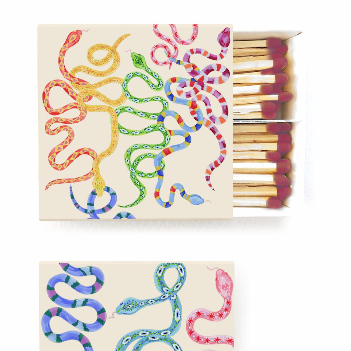 Matchbox with colorful snake designs on a white background